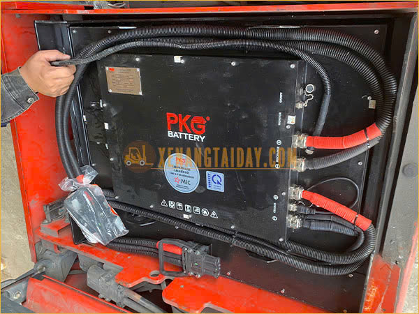 Kỹ thuật đang thực hiện việc lắp pin cho xe điện ngồi